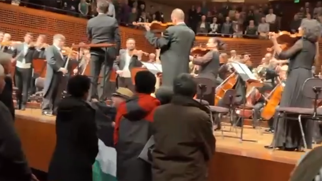 This screenshot from a video provided to J. shows a brief glimpse of a protester holding a Palestinian flag (only the black, white and green parts of the flag are visible) in front of the stage at Davies Symphony Hall in San Francisco as the Israel Philharmonic finished playing "Hatikvah," the Israeli national anthem, March 23, 2025. (Courtesy Marilyn Uzan)